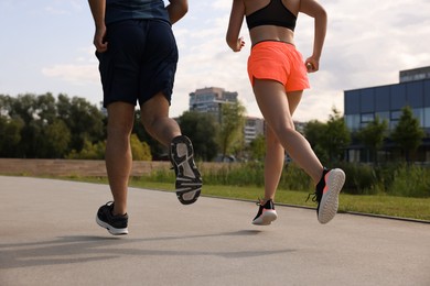 Healthy lifestyle. Couple running outdoors, closeup view