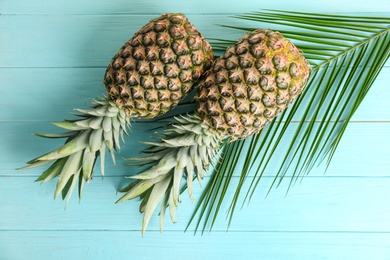 Photo of Fresh pineapples on color wooden background