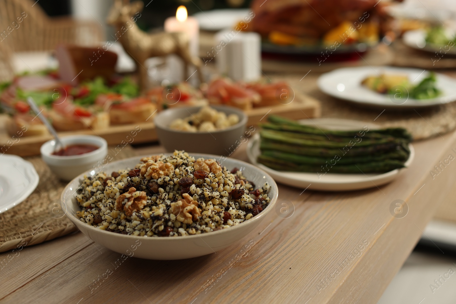 Photo of Festive dinner with traditional Christmas kutia served on table indoors. Slavic dish