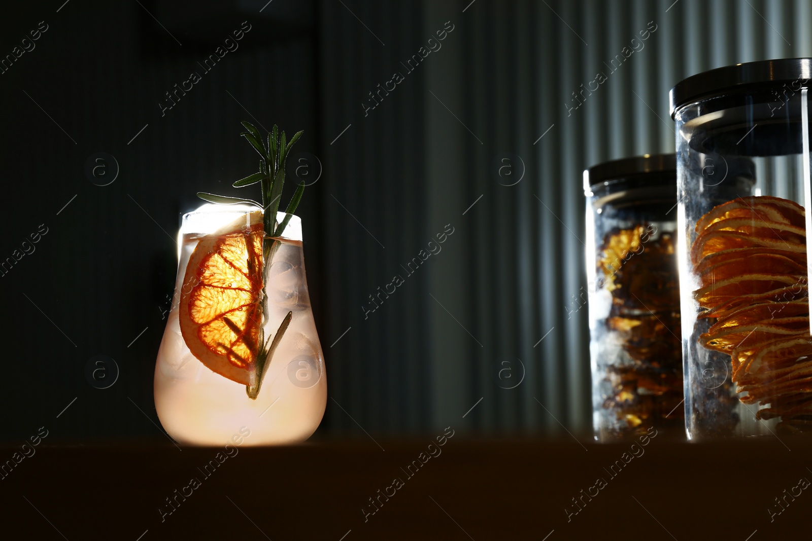 Photo of Glass of delicious cocktail with vodka on counter in bar. Space for text