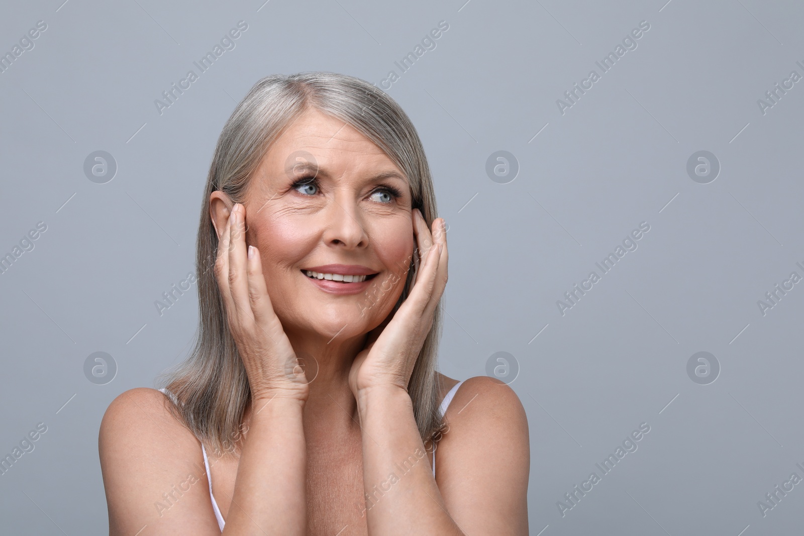 Photo of Portrait of beautiful senior woman on grey background. Space for text