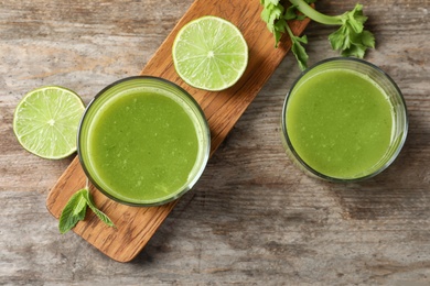 Photo of Glasses with delicious detox juice and ingredients on wooden background, top view