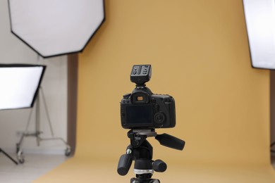 Photo of Camera on tripod and professional lighting equipment in modern photo studio
