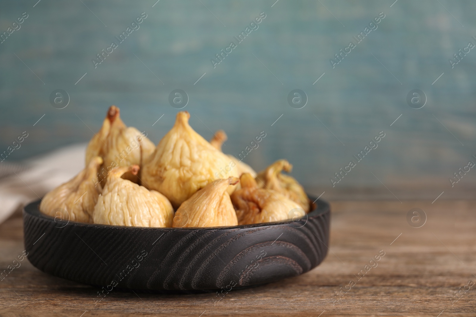 Photo of Tasty dried figs in plate on wooden table