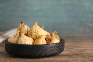 Photo of Tasty dried figs in plate on wooden table