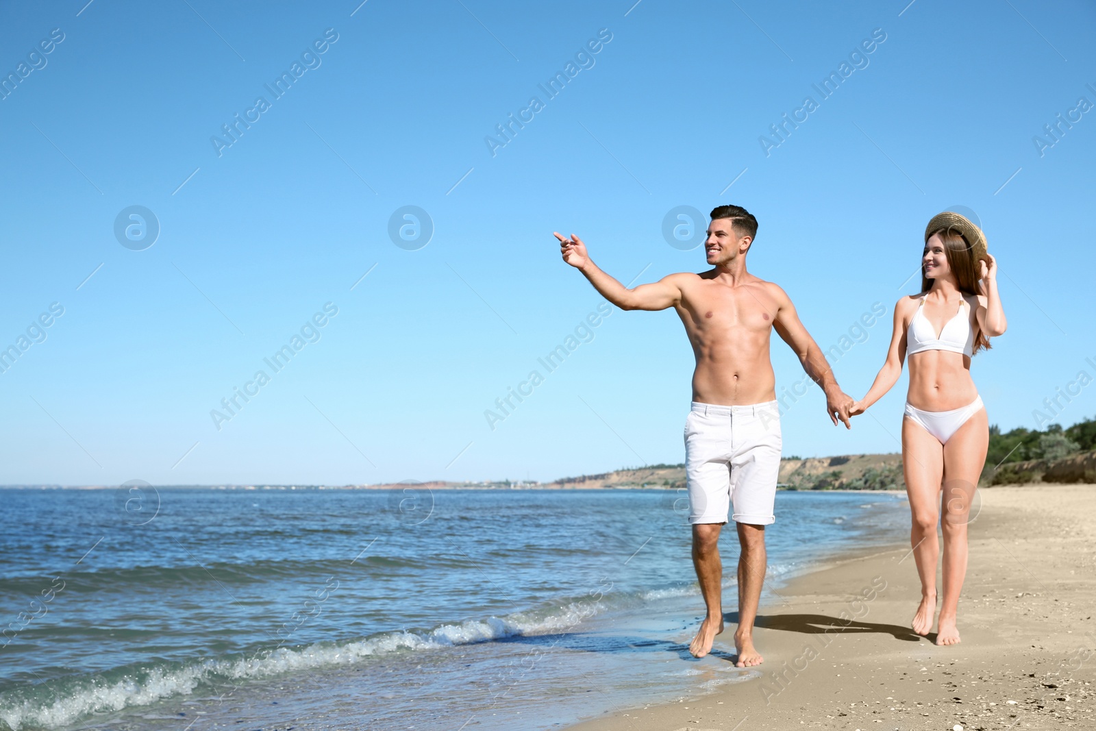 Photo of Woman in bikini and her boyfriend on beach, space for text. Happy couple