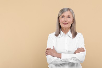 Photo of Portrait of beautiful senior woman on beige background. Space for text