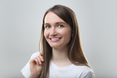 Portrait of beautiful happy woman on light grey background