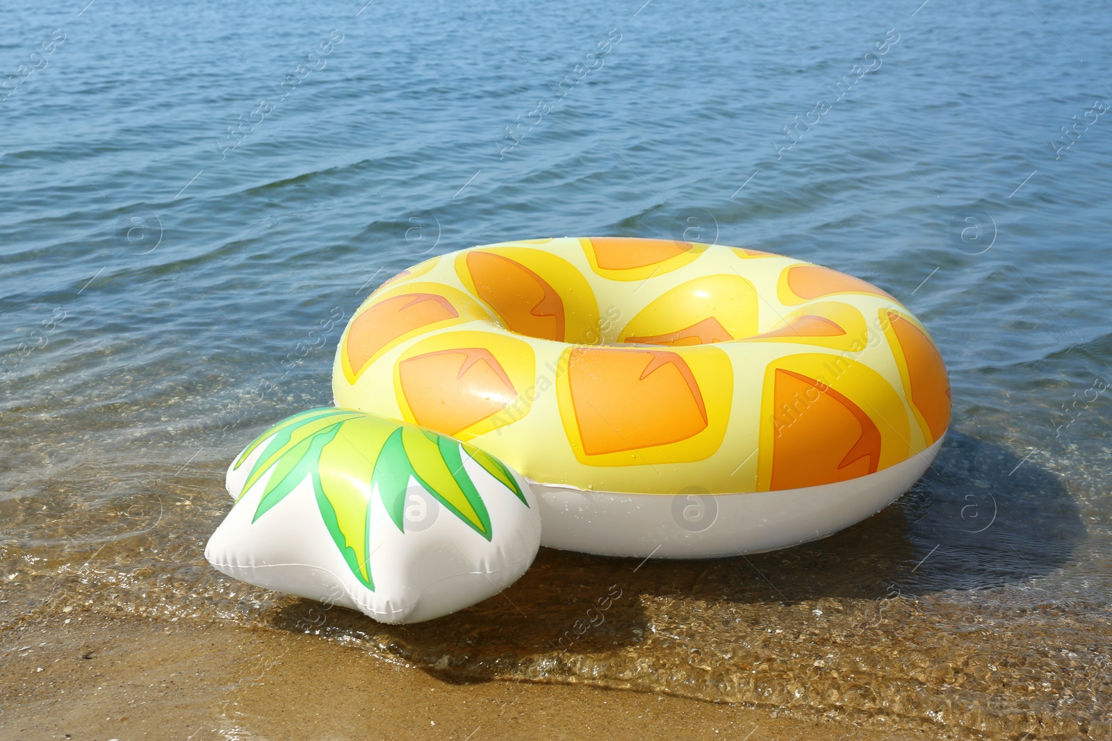 Photo of Bright inflatable pineapple ring floating on sea water