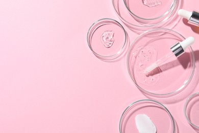 Photo of Pipette, cosmetic serum and petri dishes with samples on pink background, flat lay. Space for text