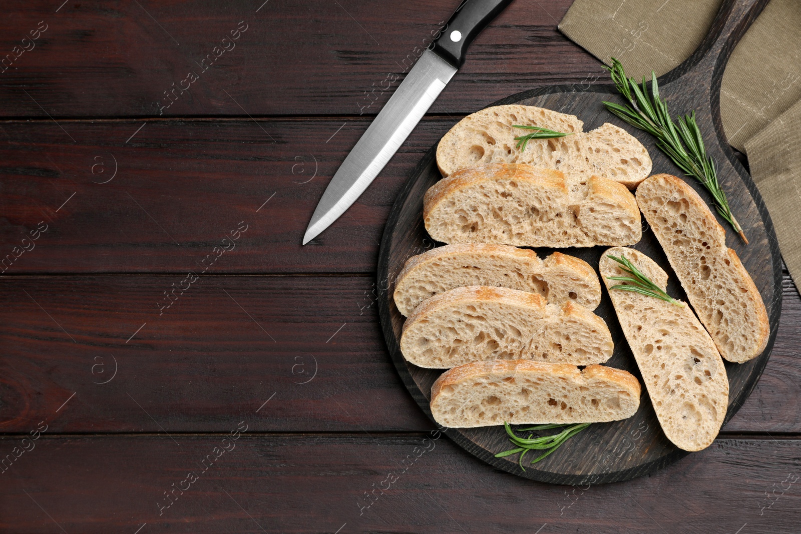 Photo of Delicious ciabatta with rosemary on wooden table, flat lay. Space for text