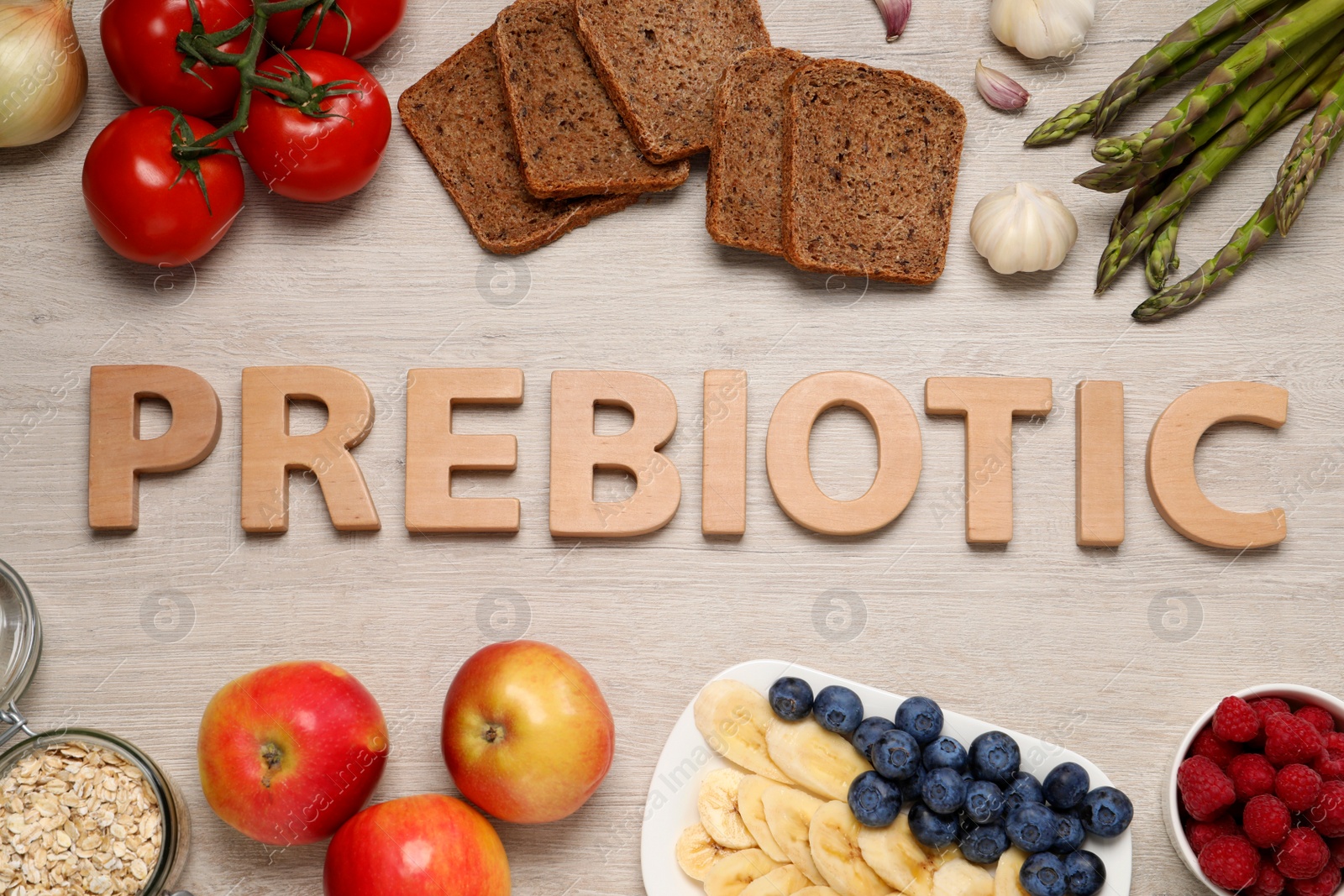 Photo of Word Prebiotic made of letters and foodstuff on wooden table, flat lay