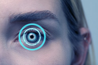 Image of Vision test. Laser reticle focused on woman's eye, closeup. Light blue tone effect