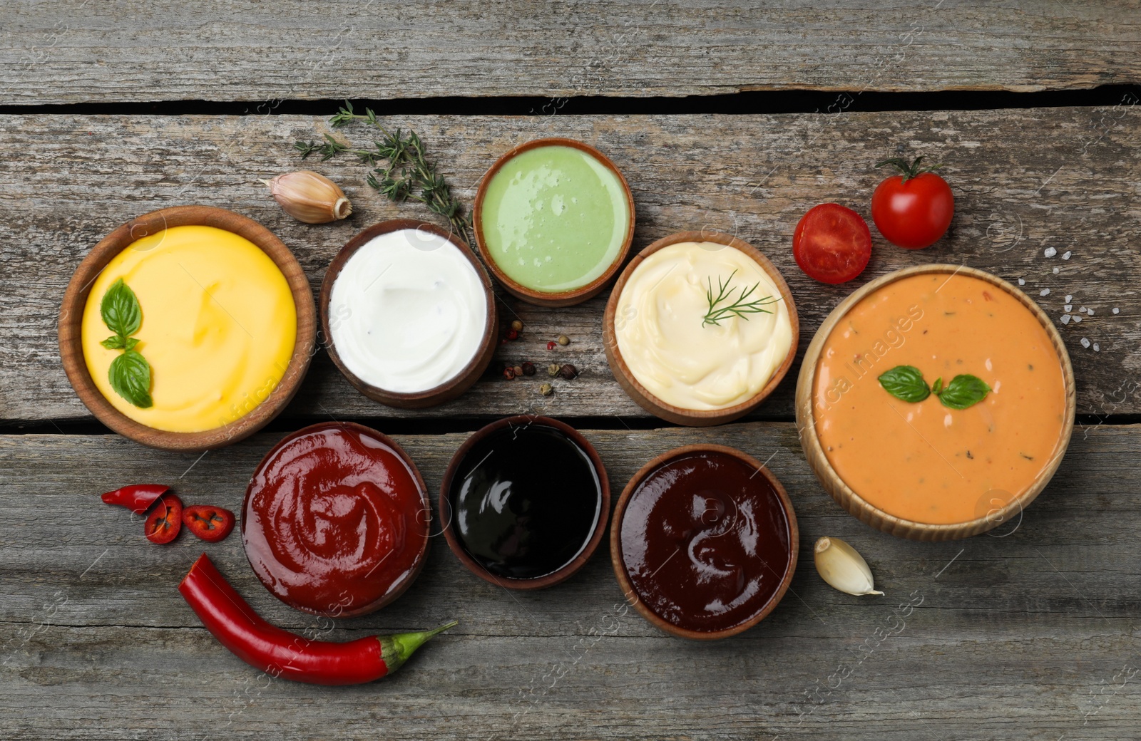 Photo of Many different sauces on wooden table, flat lay