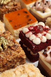 Pieces of different delicious cakes on table, closeup