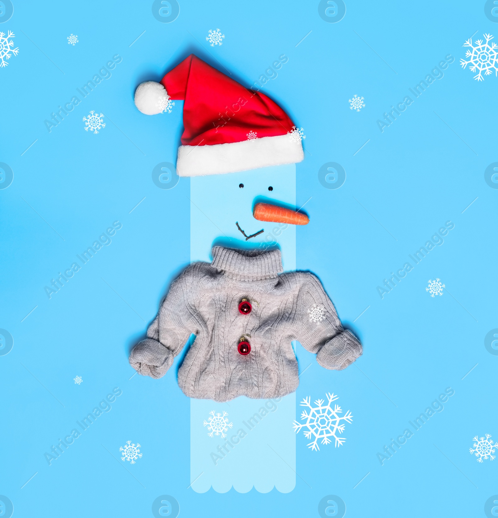 Image of Snowman with Santa hat and small sweater on light blue background, flat lay