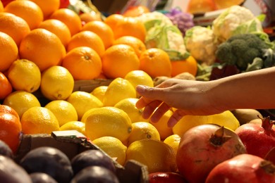 Woman picking fresh fruits at market, closeup