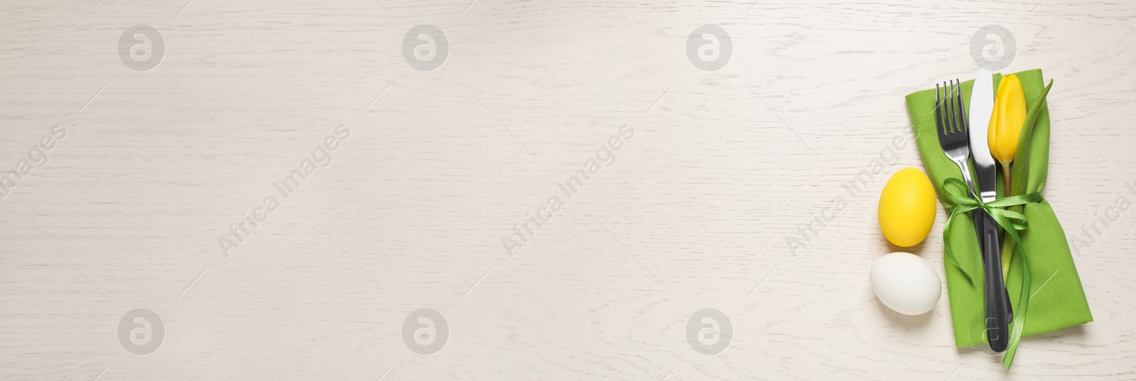 Image of Cutlery set and eggs on white wooden table, flat lay with space for text. Easter celebration