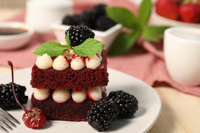 Photo of Piece of delicious red velvet cake with fresh berries served on table, closeup. Space for text