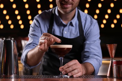 Photo of Bartender preparing Espresso Martini in bar, closeup. Alcohol cocktail
