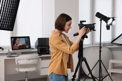 Photo of Professional photographer working with camera in modern photo studio