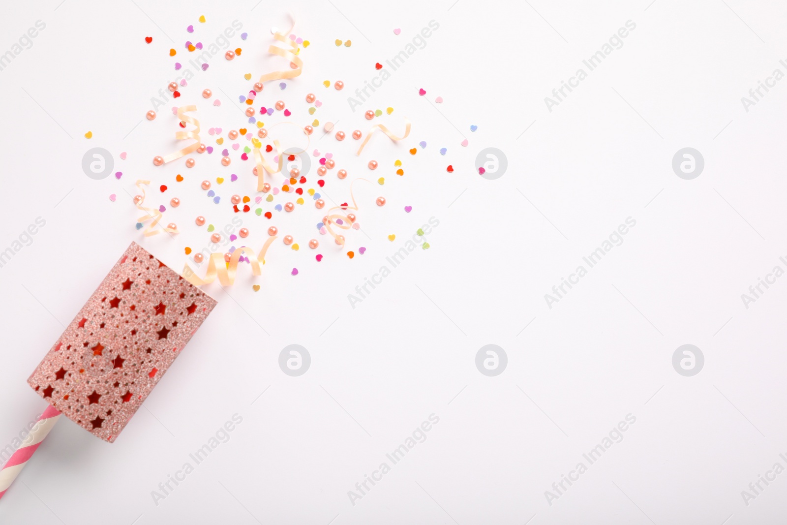 Photo of Colorful confetti and streamers with party cracker on white background, top view. Space for text