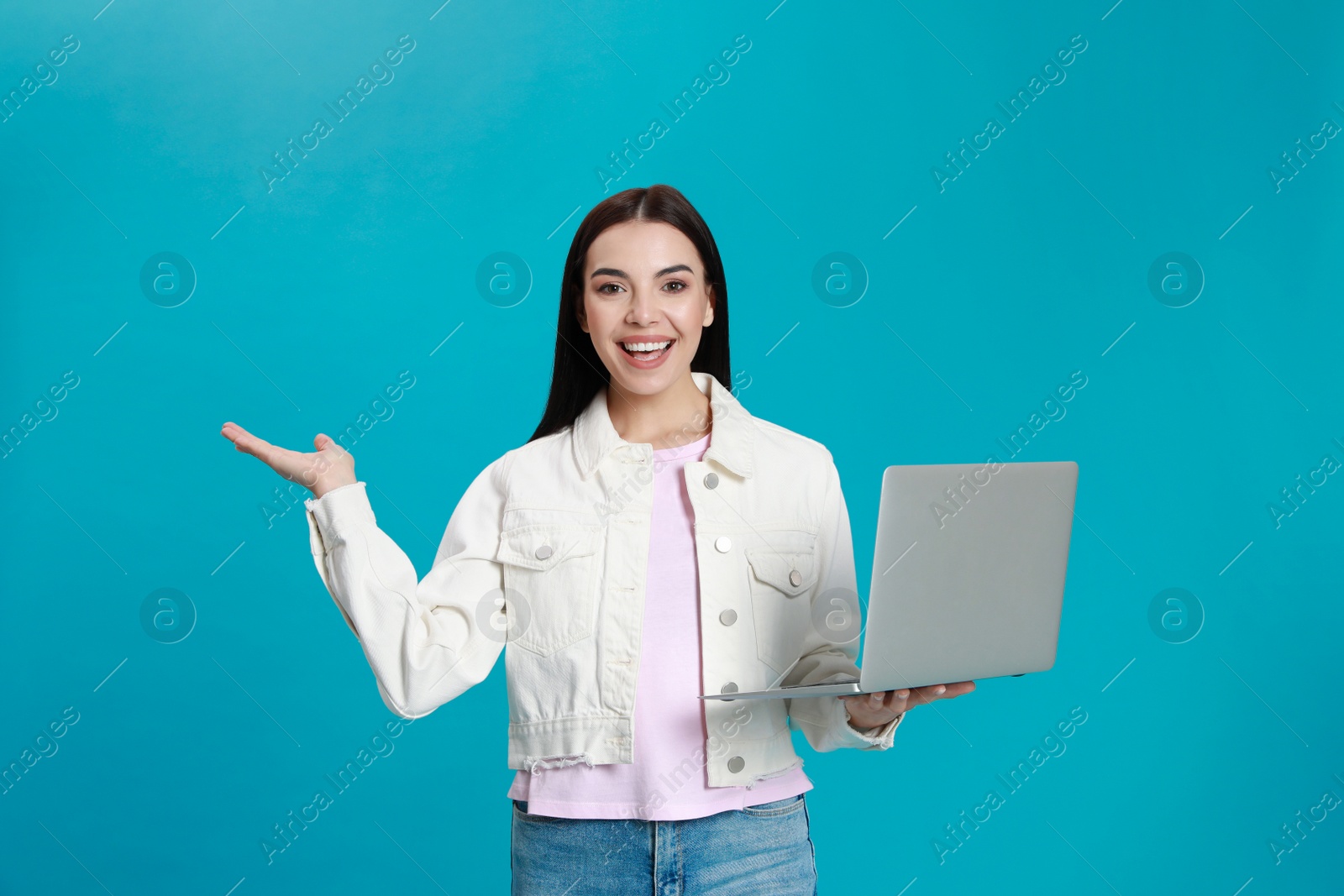 Photo of Young woman with modern laptop on light blue background