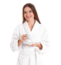 Young woman in bathrobe with cup of drink on white background