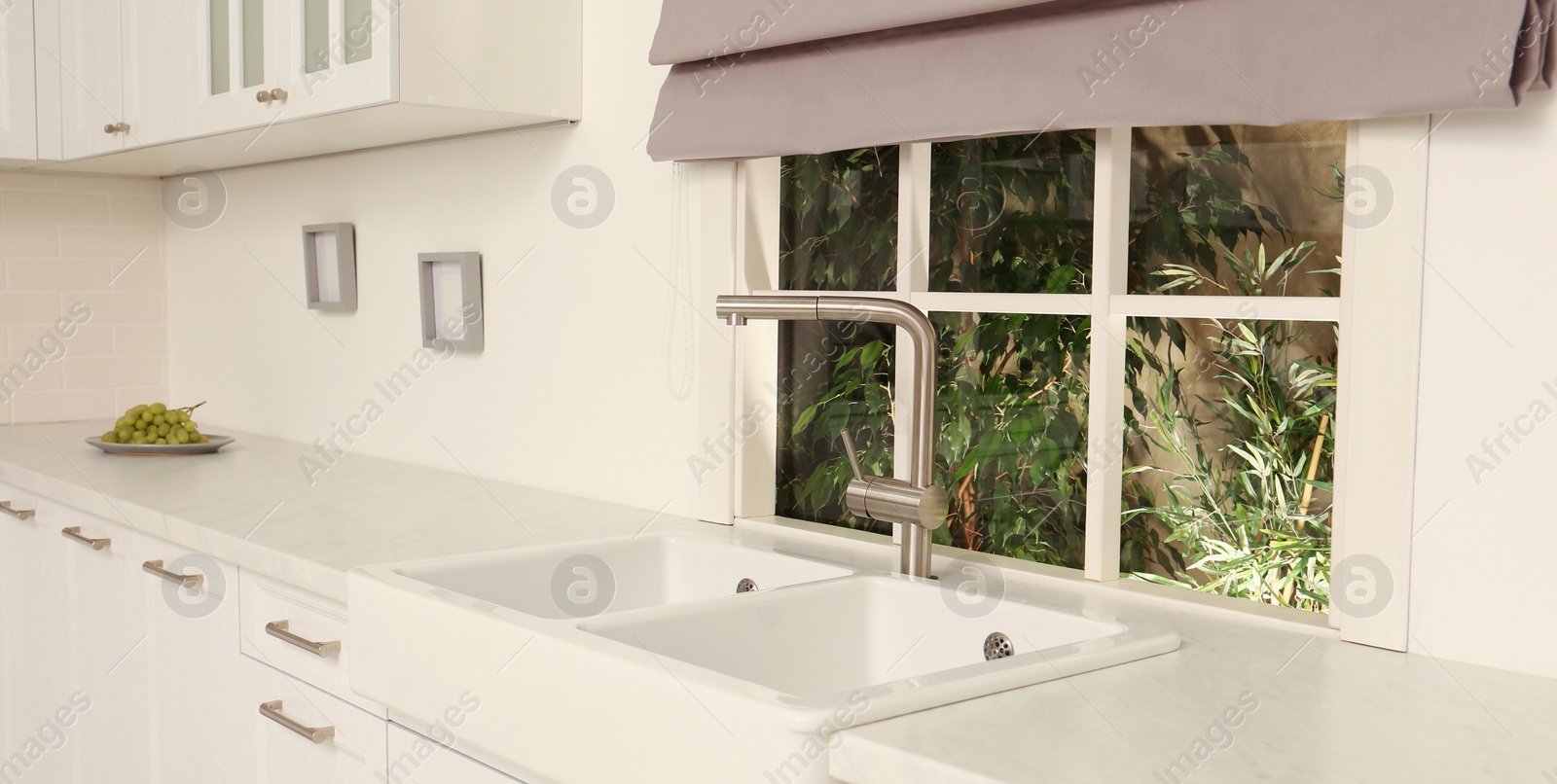 Image of White sink with tap near window in kitchen. Interior design