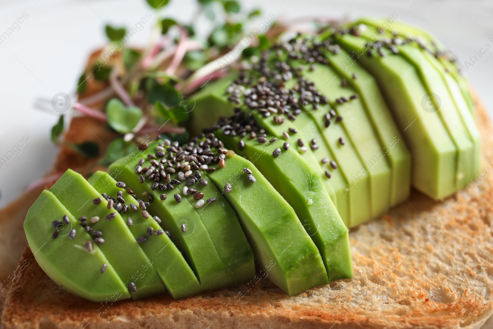 Photo of Tasty toast with avocado, sprouts and chia seeds, closeup