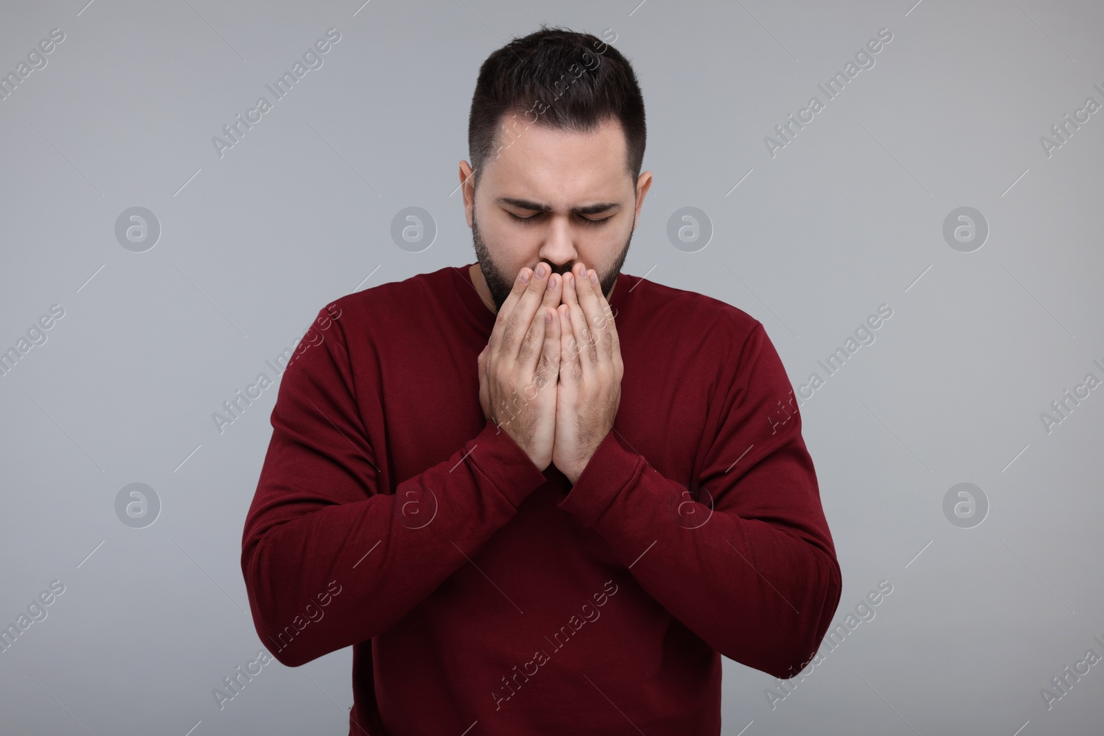 Photo of Sick man coughing on gray background. Cold symptoms