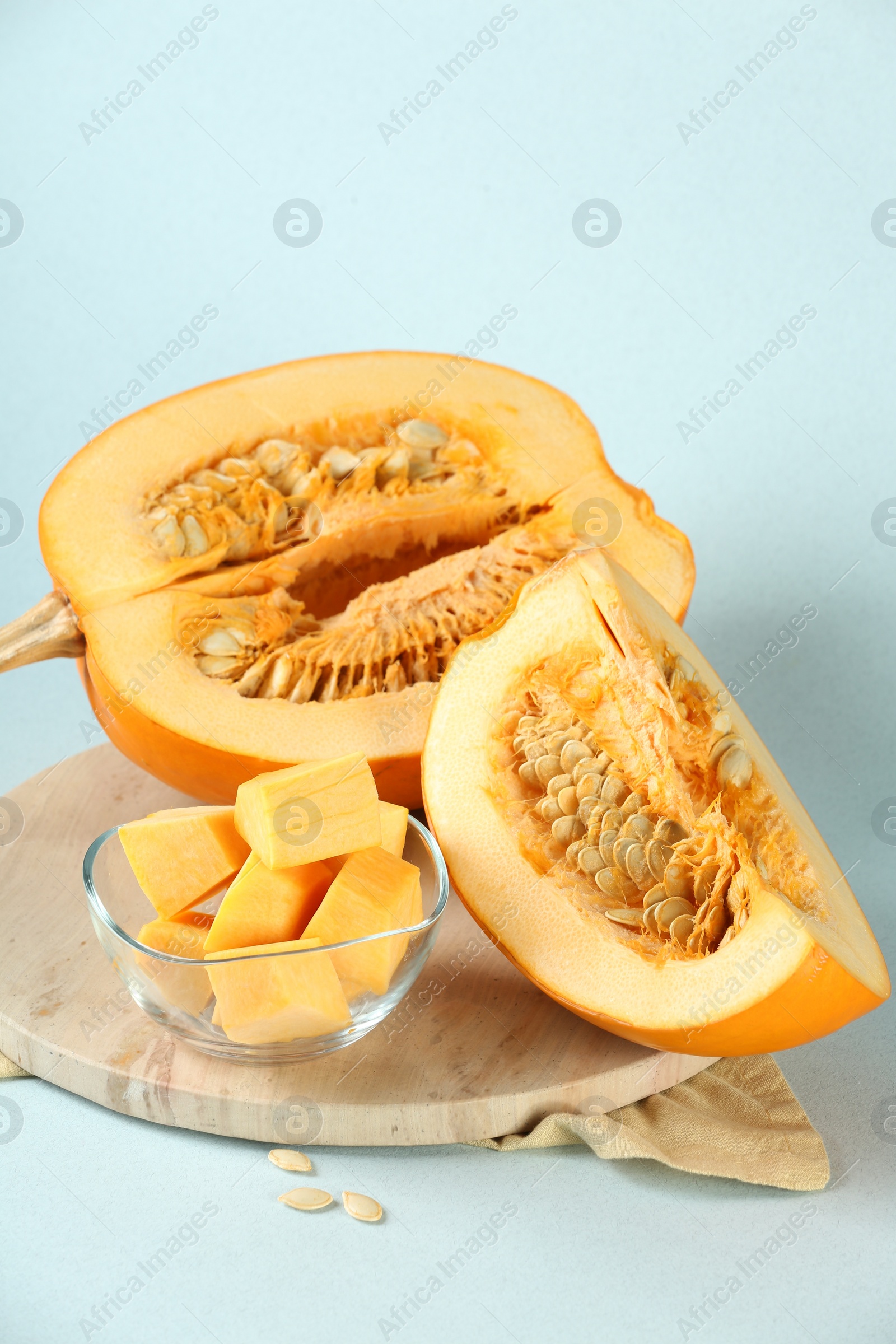 Photo of Cut fresh ripe pumpkin on light blue background