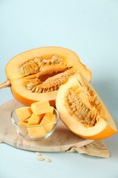 Cut fresh ripe pumpkin on light blue background