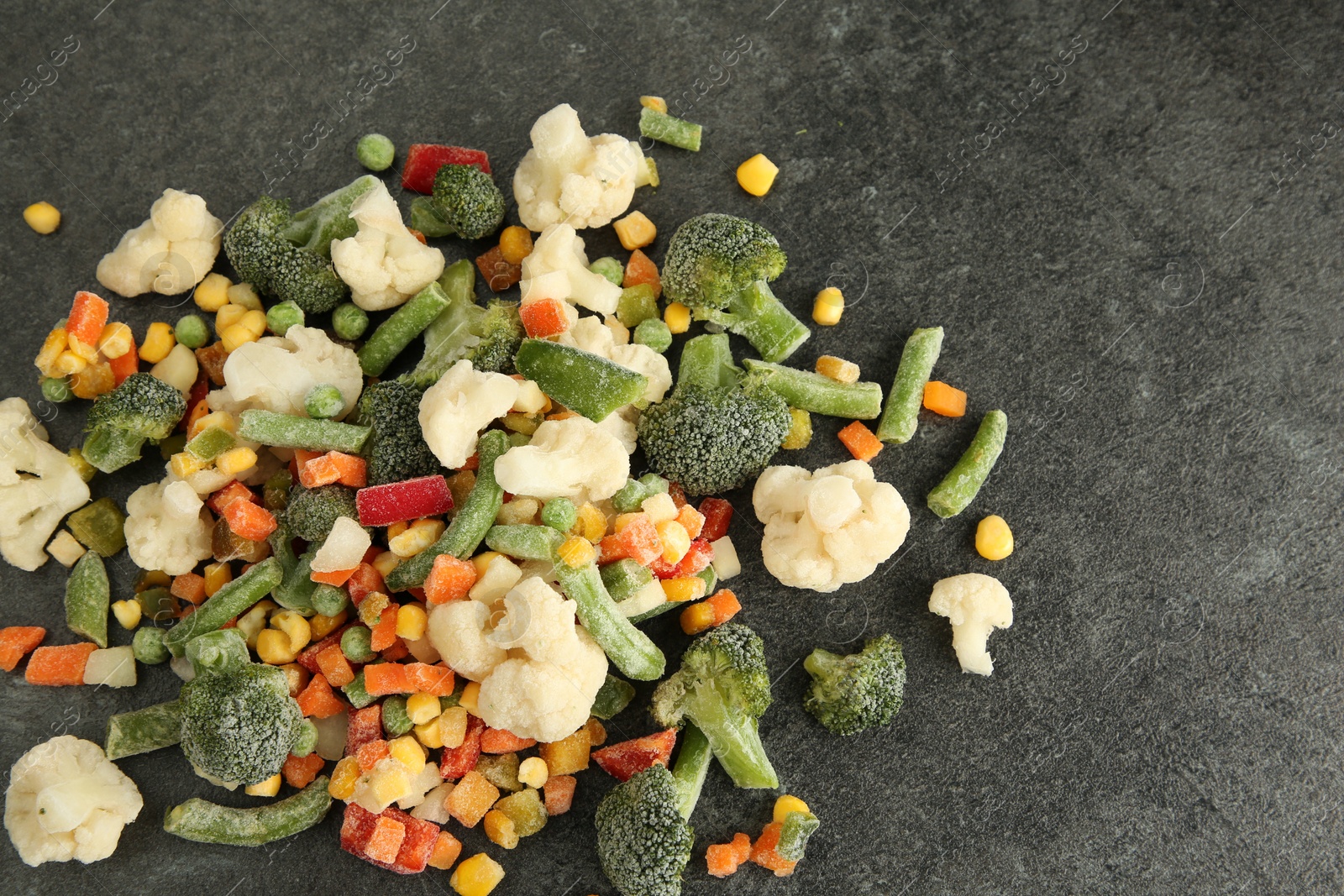 Photo of Mix of different frozen vegetables on gray table, above view