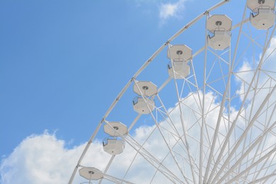 Photo of Large observation wheel against blue cloudy sky, low angle view. Space for text