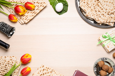 Photo of Flat lay composition with symbolic Pesach (Passover Seder) items on wooden table, space for text