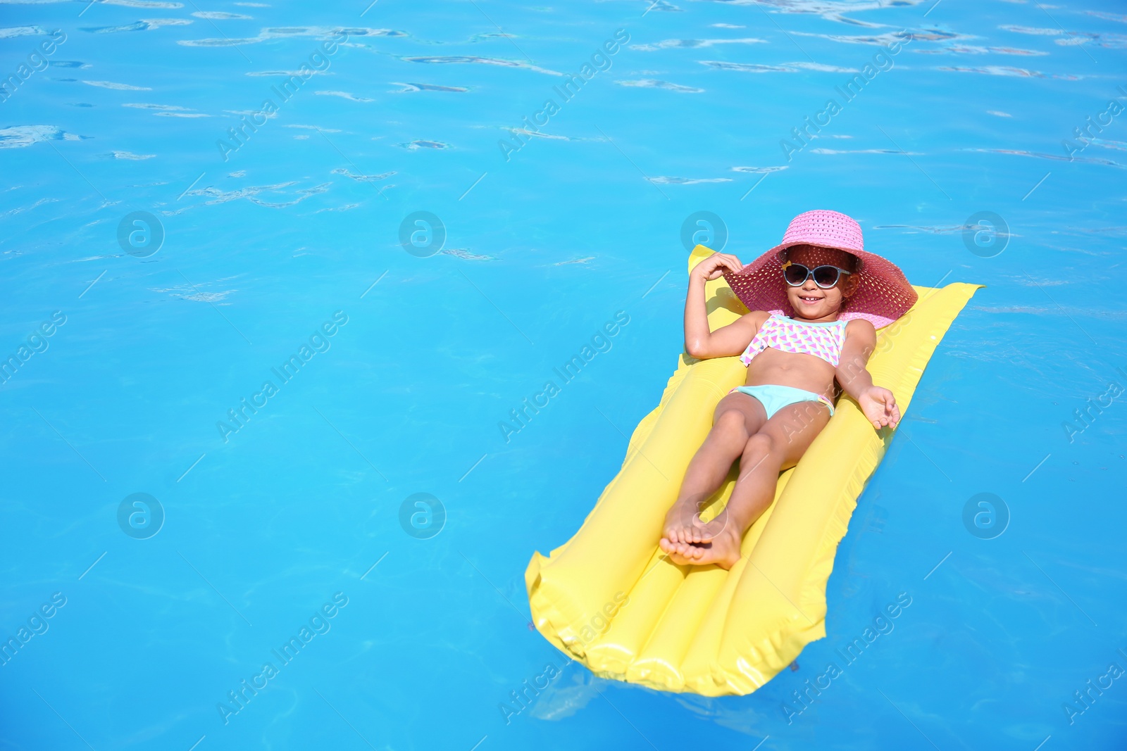 Photo of Cute little girl on inflatable mattress in swimming pool
