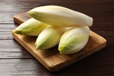 Photo of Raw ripe chicories on wooden table, closeup