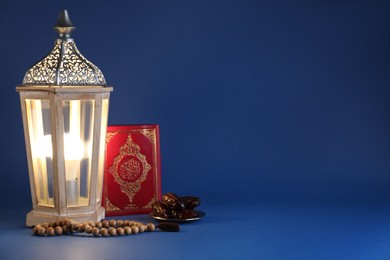Photo of Composition with Arabic lantern and quran on blue background. Space for text