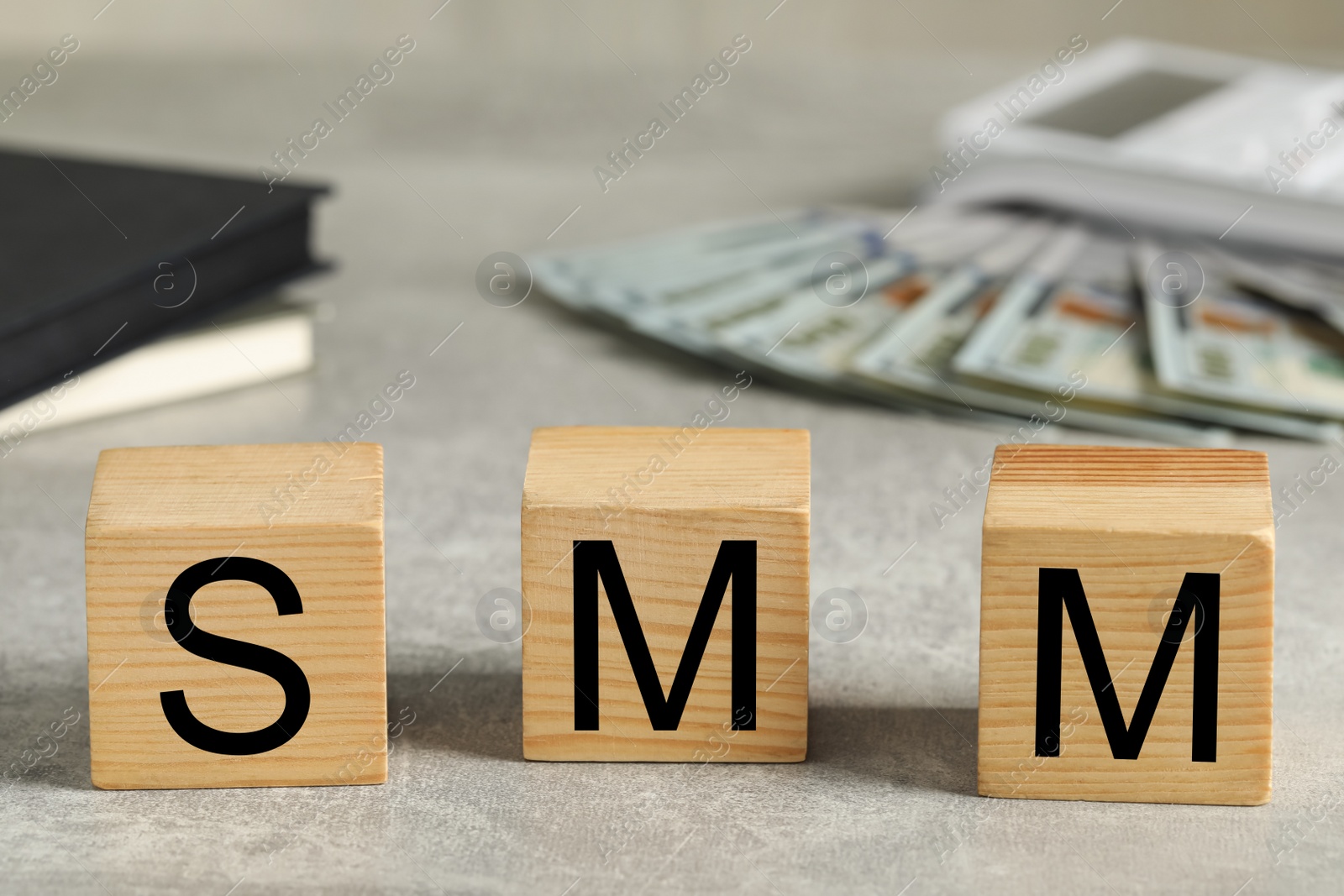 Photo of Wooden cubes with letters SMM on grey stone table