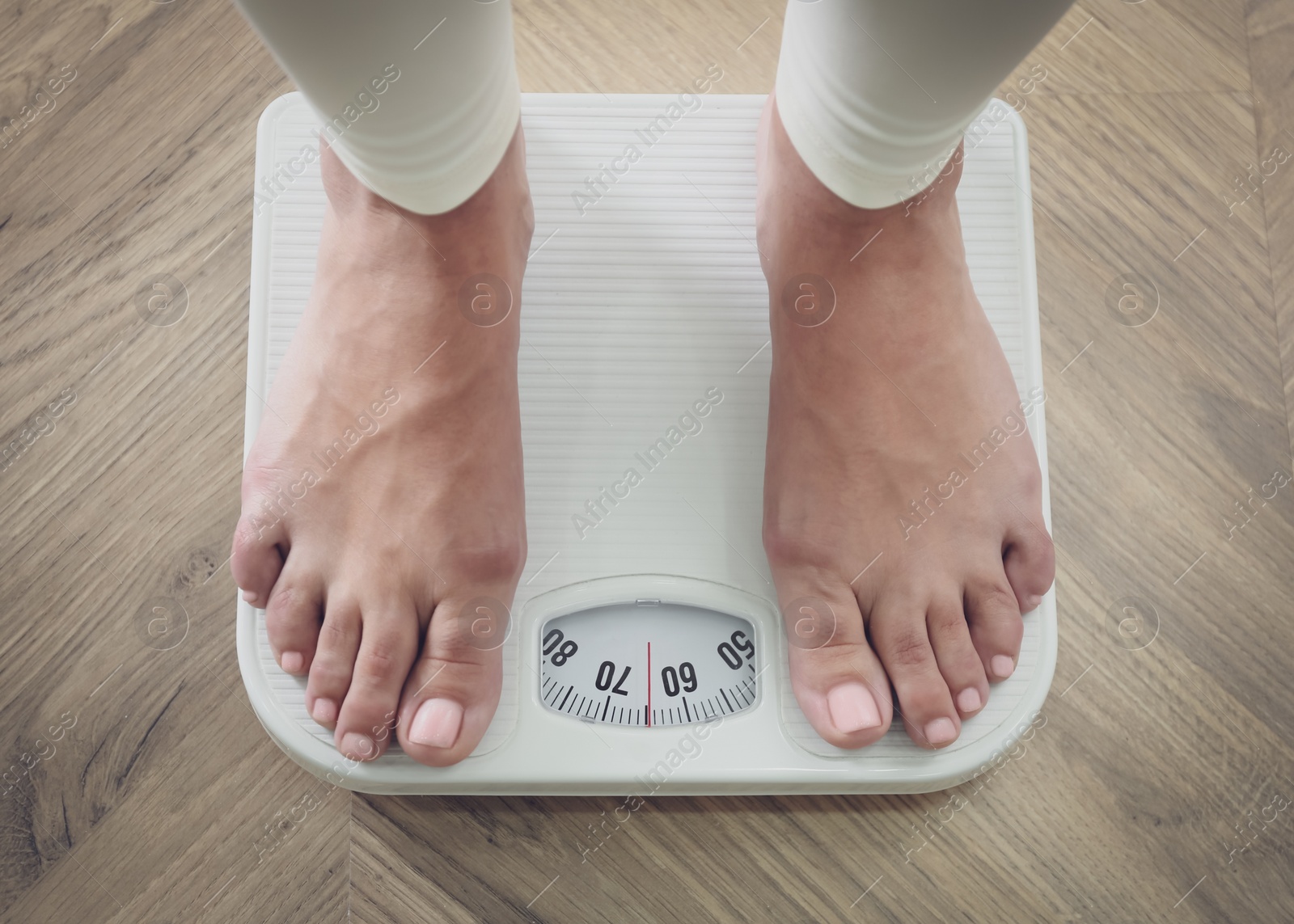 Photo of Woman using scale on floor, closeup. Overweight problem after New Year party