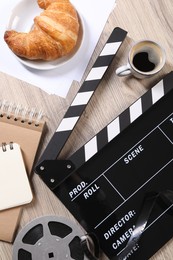 Flat lay composition with movie clapper on wooden table