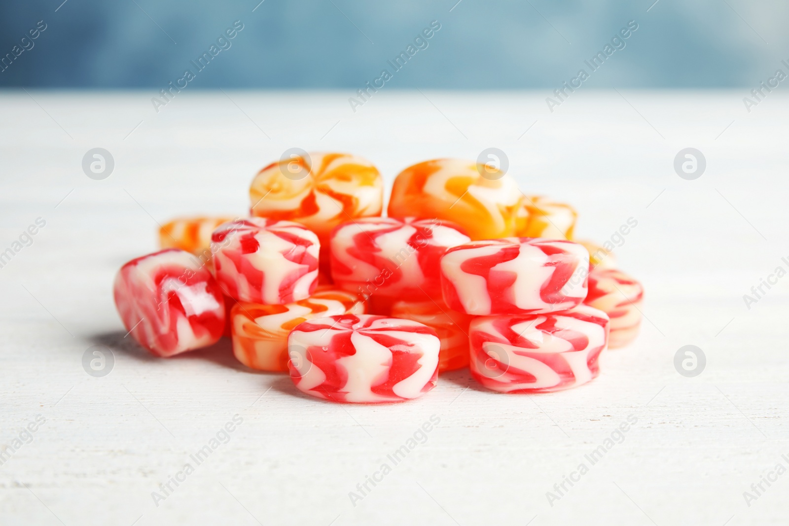 Photo of Pile of delicious colorful candies on wooden table