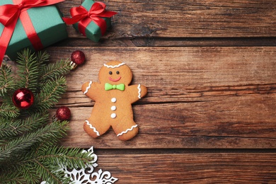 Photo of Flat lay composition with gingerbread man on wooden table, space for text