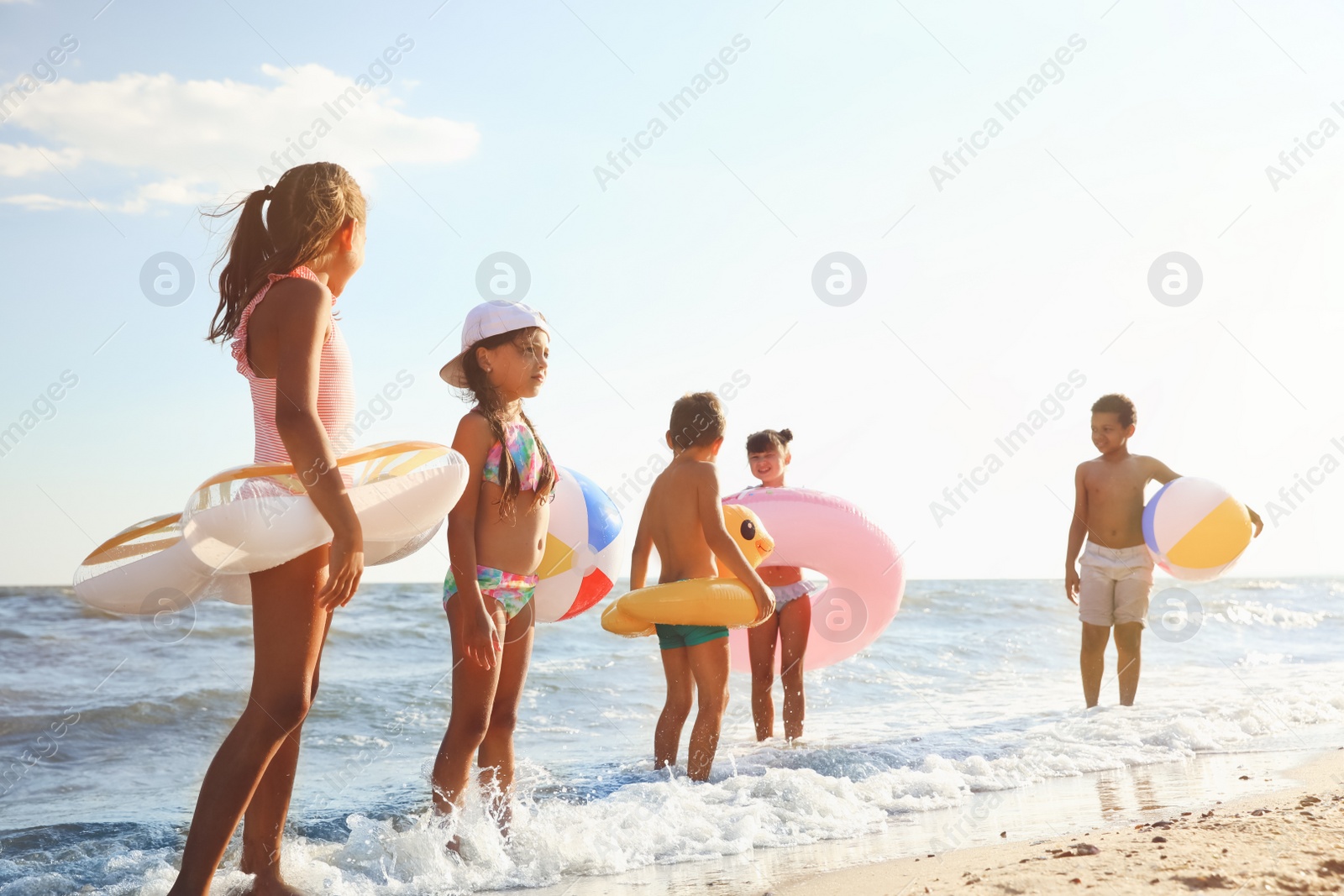 Photo of Cute children enjoying sunny day at beach. Summer camp