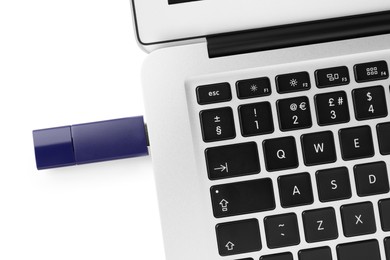 Photo of Usb flash drive attached into laptop on white background, top view