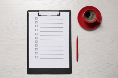 Clipboard with checkboxes, cup of coffee and pen on white wooden table, flat lay. Checklist
