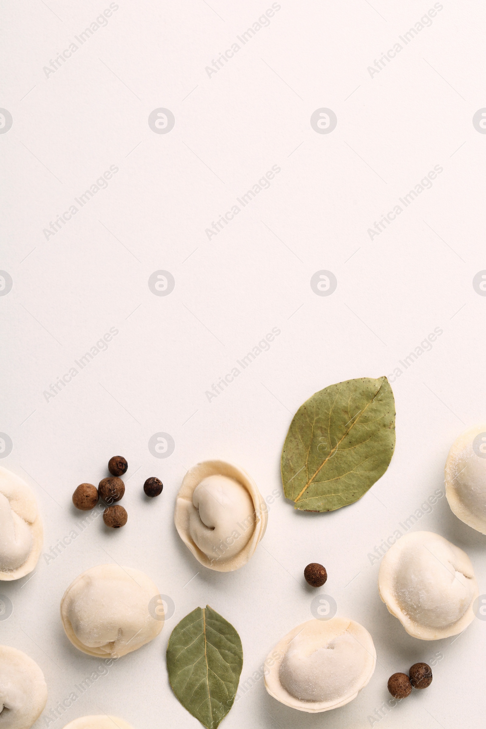 Photo of Composition with raw dumplings, bay leaves and pepper, top view