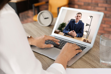 Woman using video chat for online job interview in office, closeup 