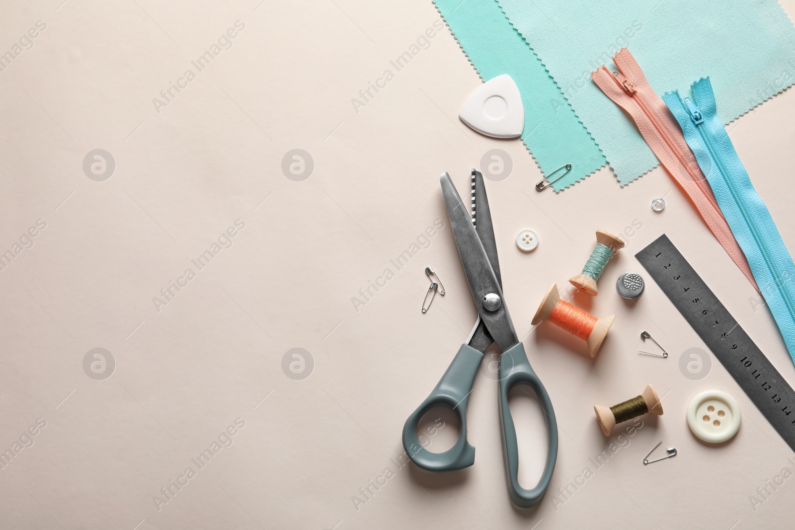 Photo of Set of tailoring accessories on light background, top view